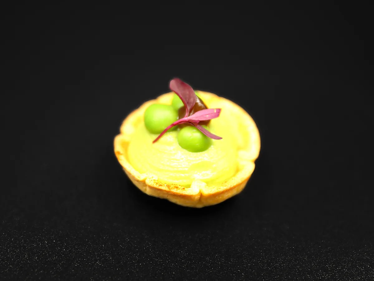 Spiced pea tartlet canapé with pea purée, fresh peas and red amaranth micro herbs, City Canapé Company London